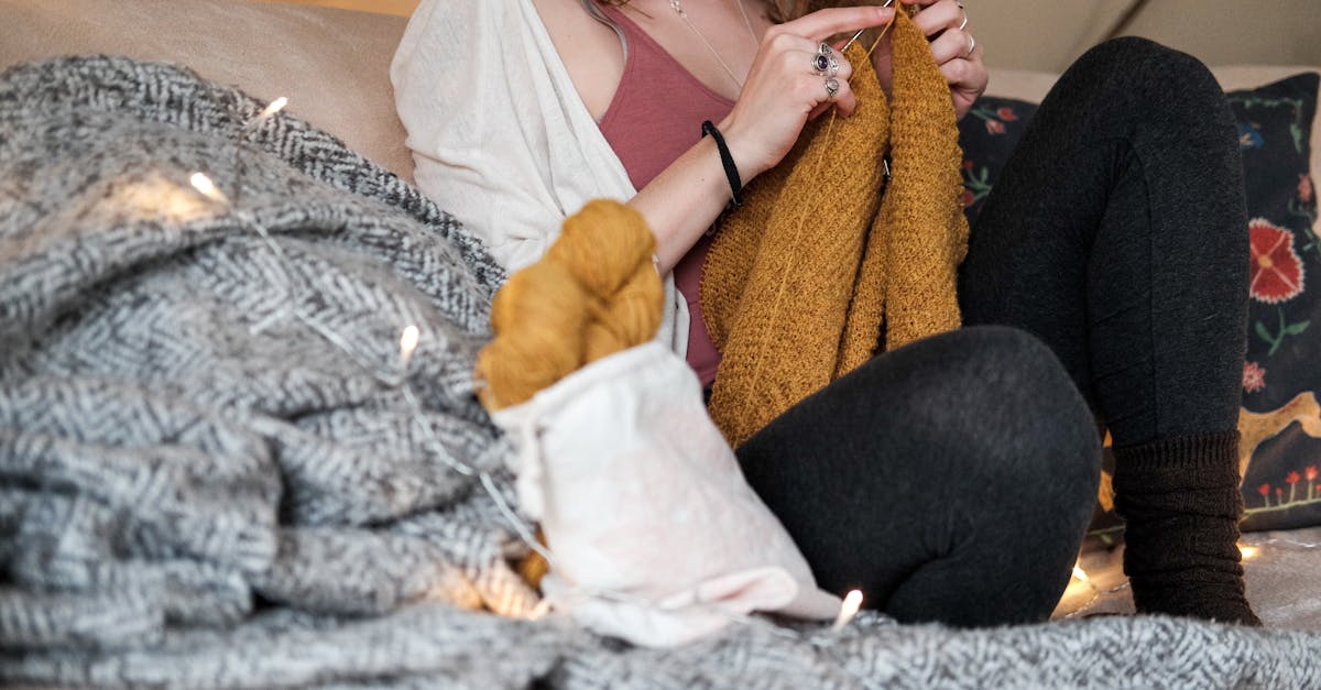 Woman Sitting On A Sofa While Knitting A Sweater