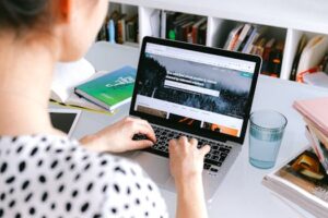 A woman using a laptop at home, browsing stock photos for creative projects.